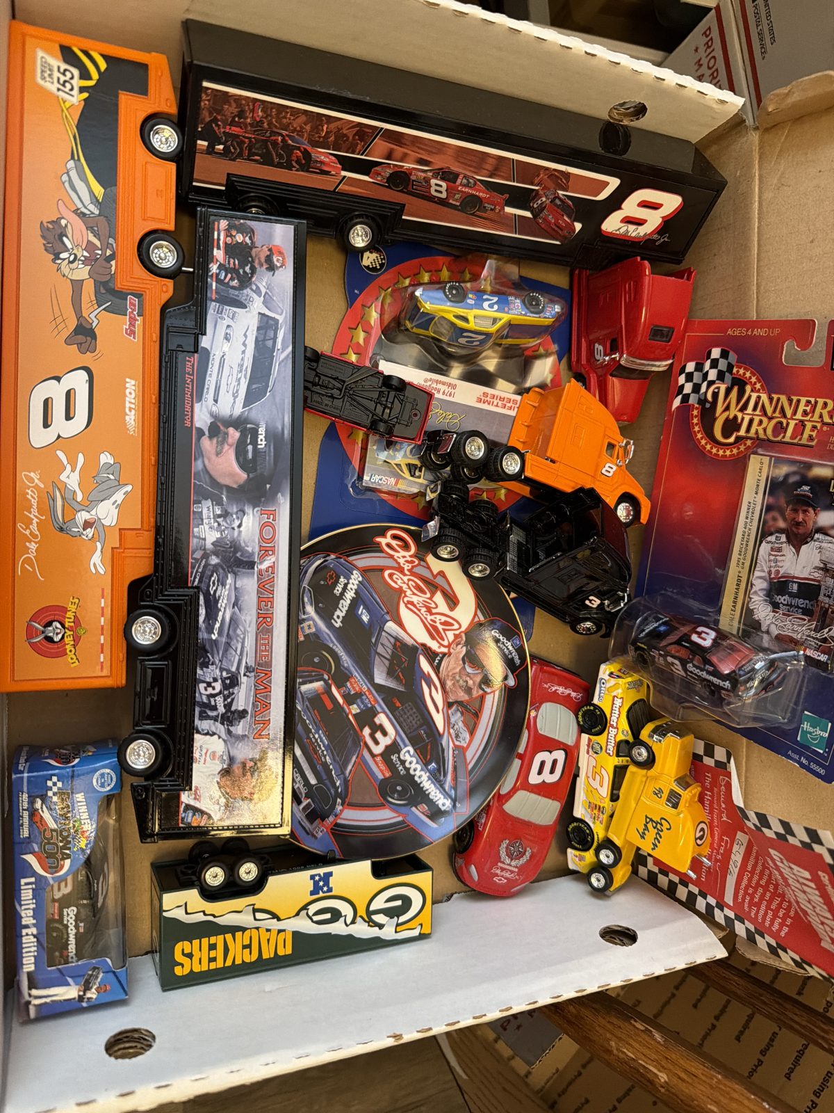 Box Of NASCAR items. Cars, Plates, Semi’s